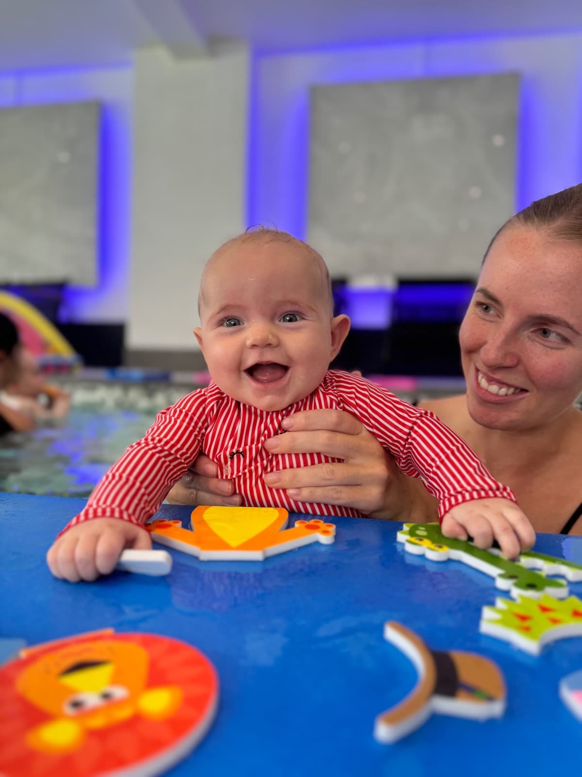 A baby holding a float in the pool